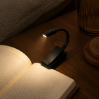 Black clip-on reading light on a bedside table